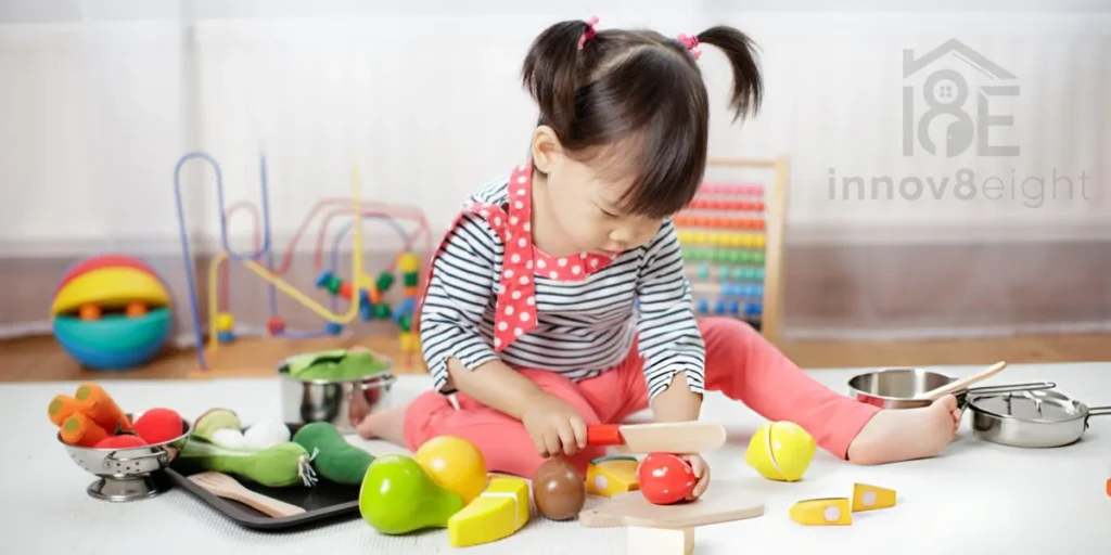 Young girl playing with a girls kitchen set, chopping pretend vegetables on a toy cutting board